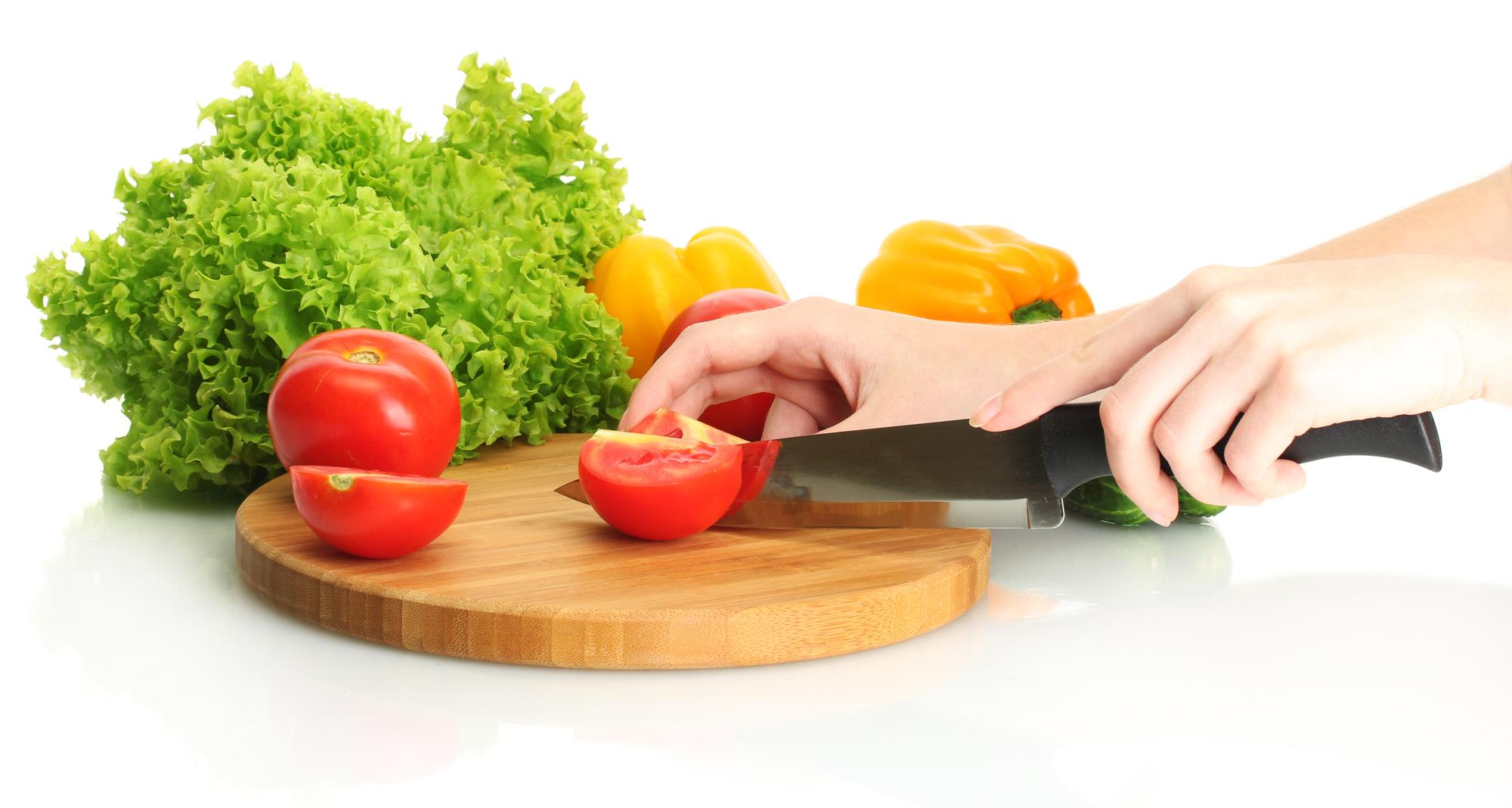 Close-up of hands slicing vegetables